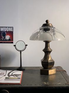 a desk with a lamp, magnifying glass and a magazine on top of it