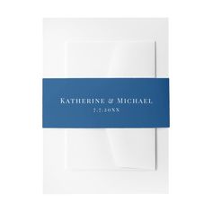 a blue and white wedding card with the name of the couple on it, in front of