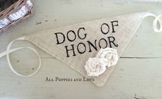 the dog of honor banner is hanging on a wooden board with an embroidered rose