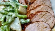 sliced pork with green beans and potatoes on a plate