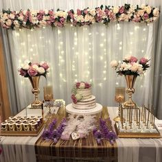 a table topped with a cake covered in pink and white flowers