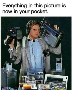 a man with headphones holding up two old radio's in front of him