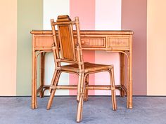 a wooden desk with two chairs next to it and a wall painted in pastel colors