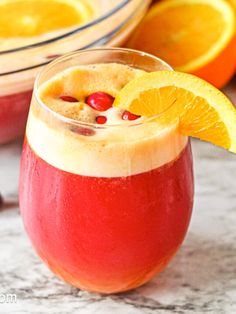 an orange and cranberry drink garnished with cherries