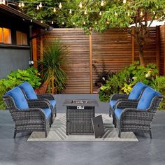 two chairs and a table on a patio with lights strung over the back yard area