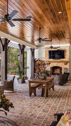 an outdoor living room with brick flooring and wooden ceiling fan mounted to the ceiling