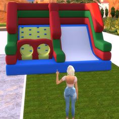 a woman standing in front of a bouncy house with an inflatable slide