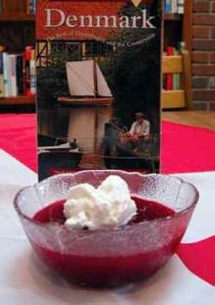 a bowl filled with whipped cream sitting on top of a table next to a book