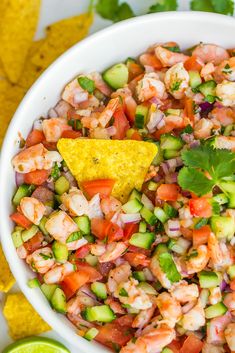 a white bowl filled with shrimp salsa and tortilla chips