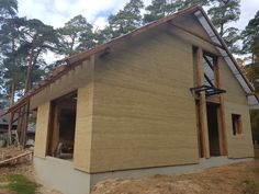 a house being built in the woods with wood framing on the front and side walls