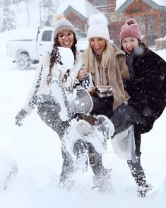 three women are playing in the snow together