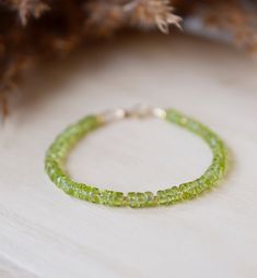 Associated with the sun, Peridot is believed to drive away dark feelings and inspire happiness! This bracelet is made with natural semi-round "wheel" shape peridot gems dotted with gold or silver beads. Wear this bracelet singly or stack it with others. Or give it to your favorite August birthday friend! STONE SIZE: 5mm (.19") Green Peridot Bohemian Jewelry, Green Bohemian Peridot Jewelry, Bohemian Green Peridot Jewelry, Green Peridot Round Bracelets, Peridot Gemstone Beads Jewelry, Adjustable Peridot Bracelet, Green Peridot Bracelet Jewelry, Handmade Lime Green Peridot Jewelry, Green Peridot Bracelet