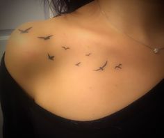 a woman's chest with birds flying in the air