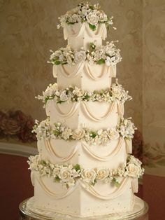 a three tiered wedding cake with white flowers on top