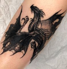 a black dragon tattoo on the leg