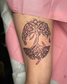 a woman's arm with a tree tattoo on it