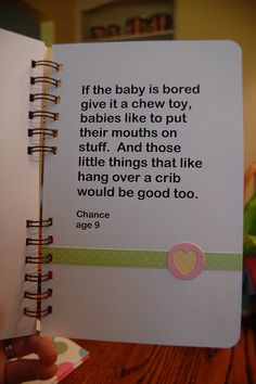 a hand holding a baby book with a quote on it