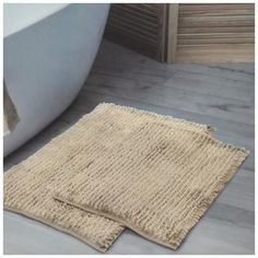 a bath tub sitting next to a rug on the floor