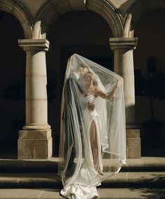 a bride and groom pose for a wedding photo in front of an old building with columns