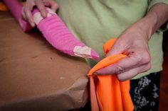 a woman is holding an orange and pink object