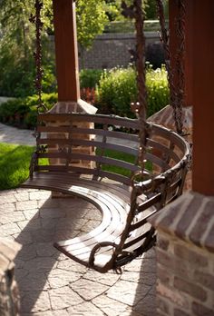 a wooden swing sitting on top of a stone patio