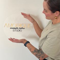 a woman holding out her hand in front of a sign that says amoire acoustic studio