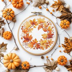 an embroidery project with autumn leaves and pumpkins