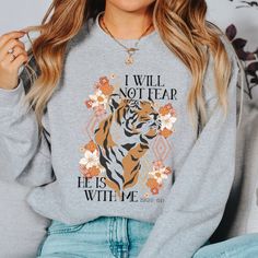 "Featuring the words \"I will not fear He is with me Isaiah 41:10\" printed on a soft fleece sweater! Christian Sweatshirt Reads: I will not fear He is with me Isaiah 41:10 Incredibly soft and durable 50% cotton, 50% polyester US Unisex S-2XL See size chart in the photos above Hand-printed just for you SIZING This sweatshirt is a unisex fit. Not sure of your size? Measure your favorite sweater's width (armpit to armpit) and then the length (top to bottom). HOW TO LOVE YOUR SWEATER Turn the garment inside out and wash cold on a delicate cycle. Lay flat to dry. Do not bleach, dry clean, or iron directly onto the design." Inspirational Long Sleeve Sweatshirt With Graphic Print, Inspirational Graphic Print Sweatshirt For Fall, Fall Inspirational Graphic Print Sweatshirt, Inspirational Graphic Print Fall Sweatshirt, Boho Christian, Sweater Boho, Girl God, Sweatshirt Trendy, Christian Sweatshirt