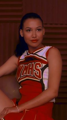 a young woman in a cheerleader uniform posing for a photo with her hands on her hips