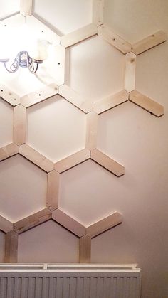 the wall is made up of hexagonal wooden pieces and has a light fixture on it