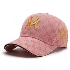 a pink baseball cap with gold lettering on the front and side, featuring a yankees logo