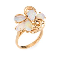 Stylish vintage opal ring (circa 1970s) crafted in 14 karat yellow gold.   Five cabochon cut teardrop shaped opals measure 8mm x 5mm (estimated at 0.50 carats each - 2.50 carats total estimated weight). The opals are in very good condition and free of cracks or crisps.   The opals are set into an open mosaic design. The ring is great for day or evening wear. The opals exhibit a good colour matrix with green, blue, turquoise, yellow and purple colour flashes. The medium rise ring (11mm - 0.43 inc Fine Jewelry Yellow Gold Pear-shaped Opal Ring, Fine Jewelry 14k Gold Pear-shaped Opal Ring, 14k Gold Pear-shaped Opal Ring Fine Jewelry, Pear-shaped 14k Gold Opal Ring Fine Jewelry, 14k Gold Pear-shaped Opal Ring, Pear-shaped 14k Gold Opal Ring, Pear-shaped Yellow Gold Opal Ring, Elegant 14k Gold Pear-shaped Opal Ring, Yellow Gold Pear-shaped Opal Ring