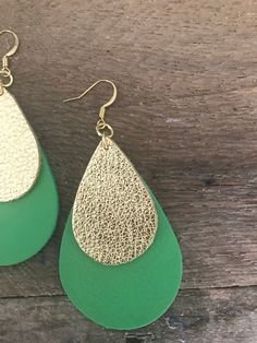 Cheer for your favorite team with these inspired Green and Gold layered earrings. You'll get a double take when you wear these beautiful double layer leather earrings. They add a carefree, boho vibe to your everyday look. With these layered leather teardrop earrings, your wardrobe has the perfect fixer upper for even your least put-together days. These statement earrings are the perfect gift for friends, mothers, sisters, teachers, or any lady in your life. OVERVIEW This listing is for one pair Green Leather Dangle Jewelry, Trendy Faux Leather Jewelry For Everyday, Trendy Faux Leather Everyday Jewelry, Double Take, Boho Vibe, Go Green, Leather Earrings, Teardrop Earrings, Favorite Team