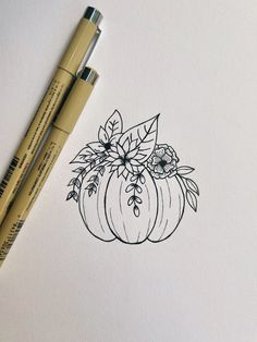 a drawing of a pumpkin with flowers and leaves on it, next to two markers