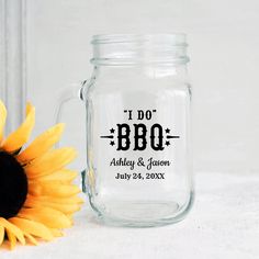 a mason jar with the words i do bbq on it next to a sunflower