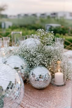 White flowers and disco balls Christmas Table Baby’s Breath, Mini Disco Ball Centerpiece, Disco Engagement Party Ideas, Disco Elegant Party, Disco Balls Party Decor, Crazy In Love Engagement Party, Nye Wedding Table Decor, Disco Ball And Candles, Disco Ball On Table