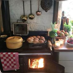 an oven with food cooking in it next to a table full of fruit and vegetables