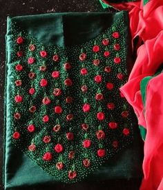 a piece of cloth with red flowers on it and a green border around the edges