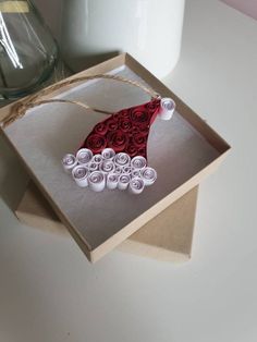 an ornament made out of rolled up paper on top of a cardboard box