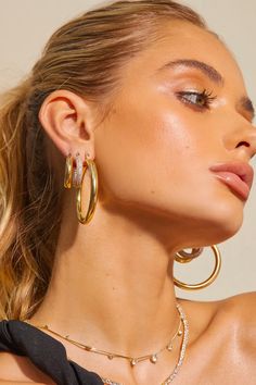 a woman wearing large gold hoop earrings