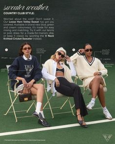 three women sitting in lawn chairs on a tennis court, one wearing sunglasses and the other with an oversized sweater