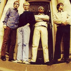 four men standing in front of a door with their arms crossed