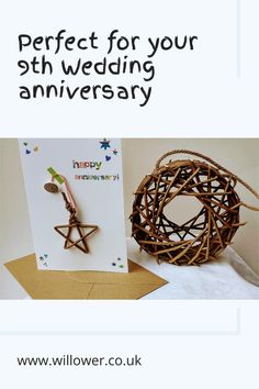 A white card with rainbow writing which says happy anniversary with a willow star on it, next to a circular willow bird feeder Willow Star, Star Cards