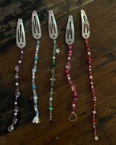 five different colored beads and silverware on a wooden table