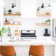 two orange chairs sitting in front of a white counter top next to a microwave oven