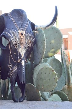 an animal statue is standing next to some cactus