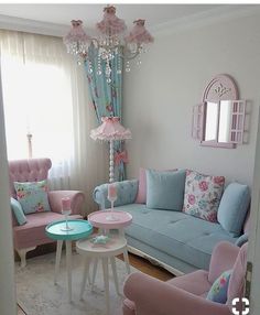 a living room filled with furniture and a pink chandelier hanging from the ceiling