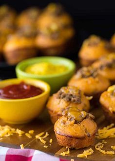 some muffins are on a cutting board with condiments