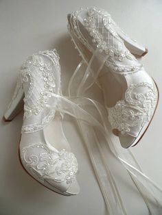 three pairs of shoes with white lace and bows