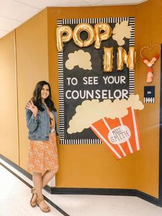 a woman standing in front of a popcorn sign